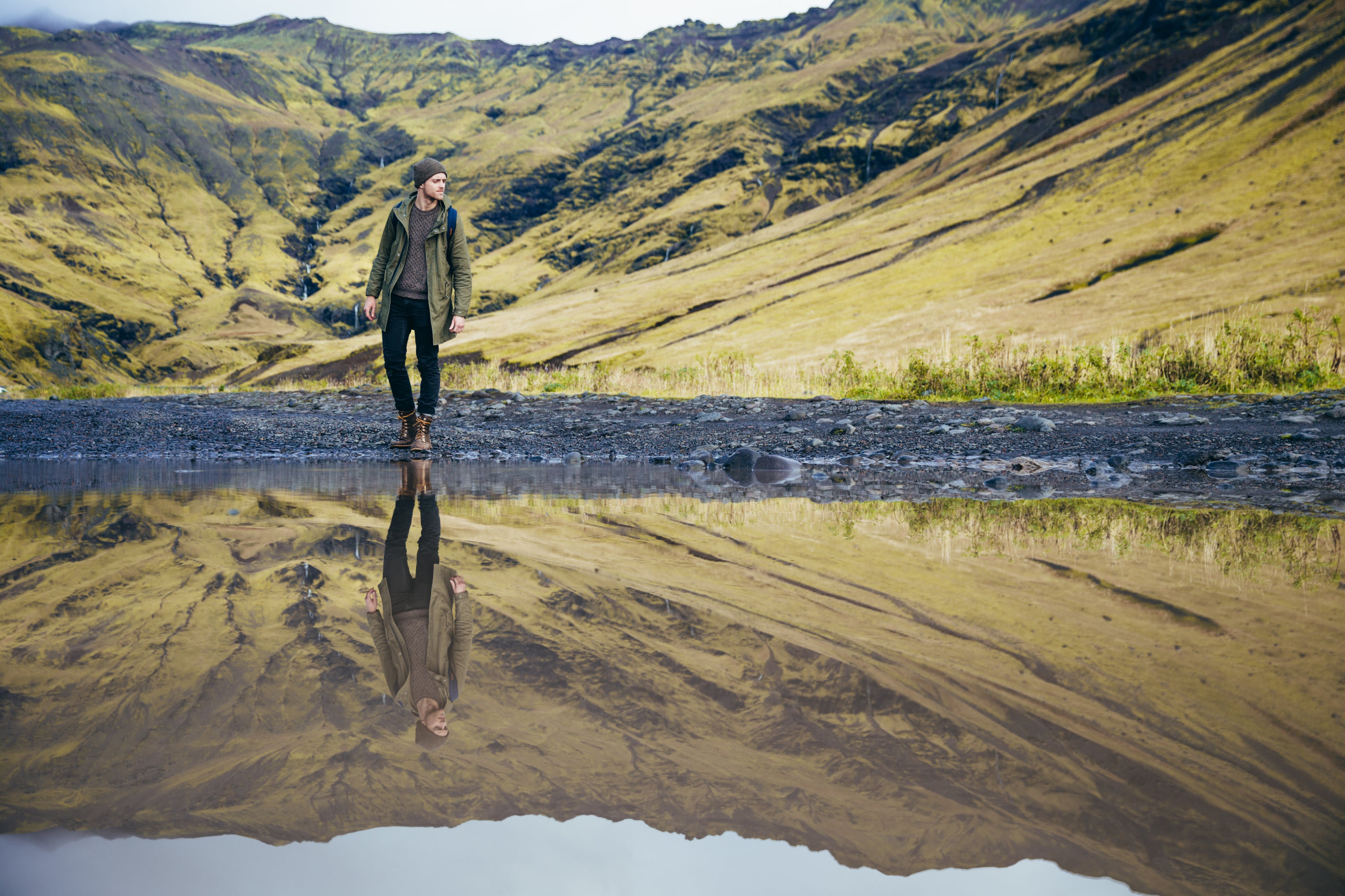 Man's reflection mirrored in mountain lake